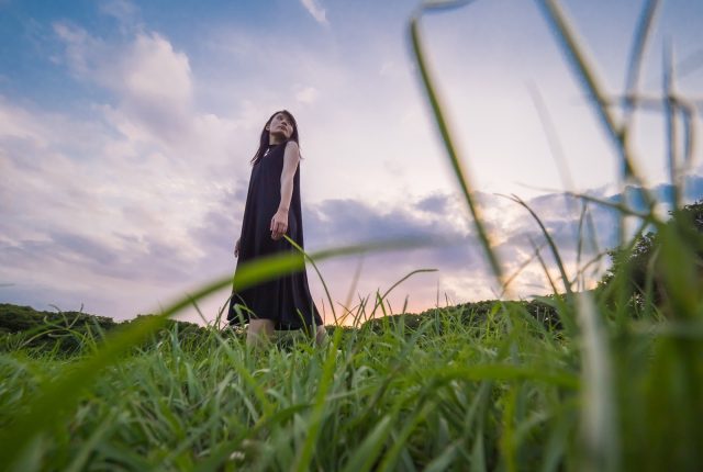 草原にたたずむ女性の画像